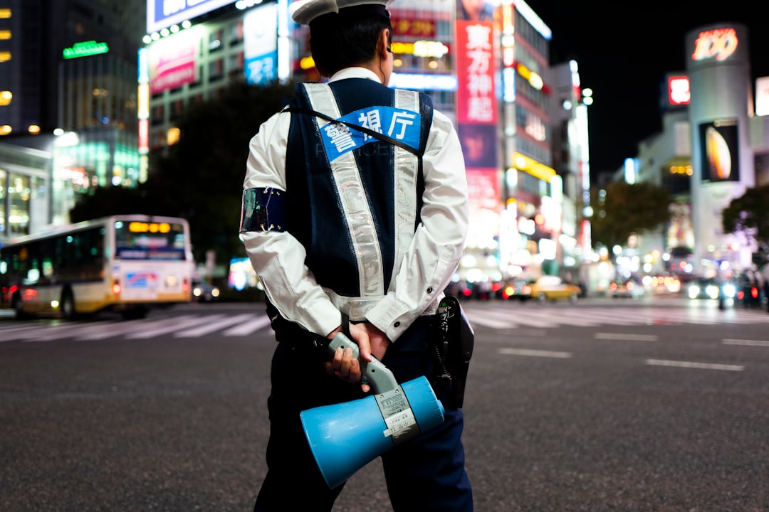 man in blue and white jacket holding blue plastic cup