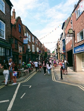 A bustling high street with small shops and people engaging in commerce.
