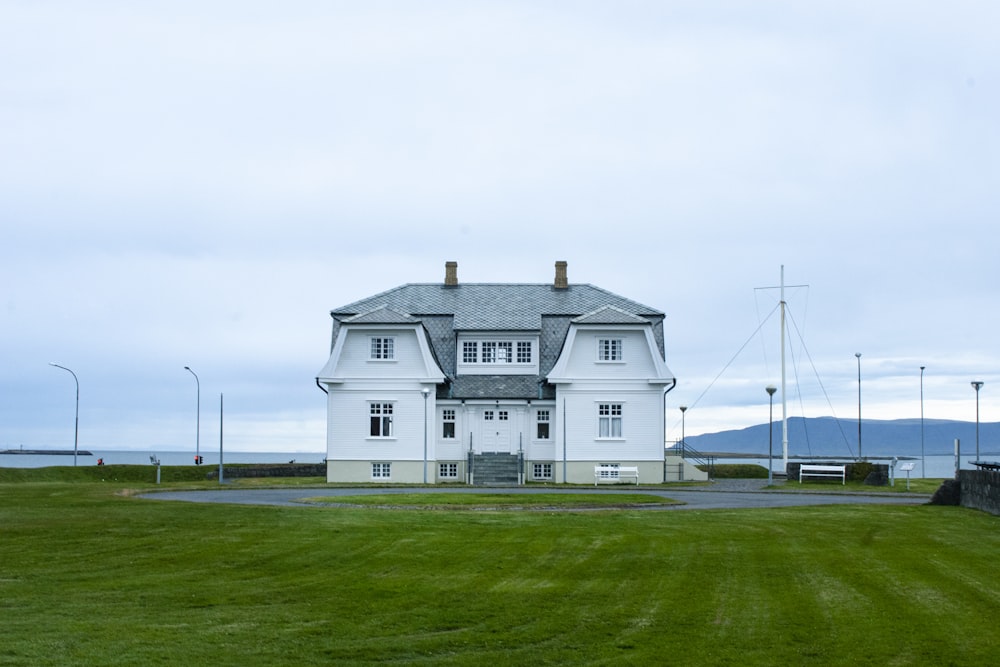 white and gray house on green grass field under white sky during daytime