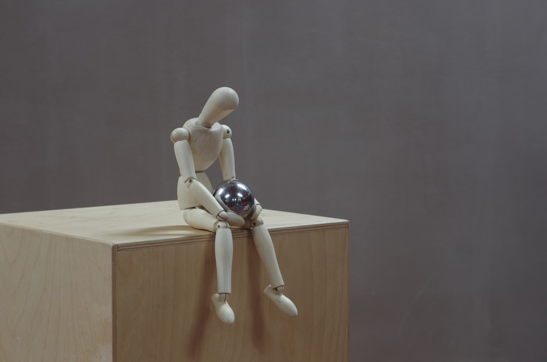 white wooden human figure on brown wooden table