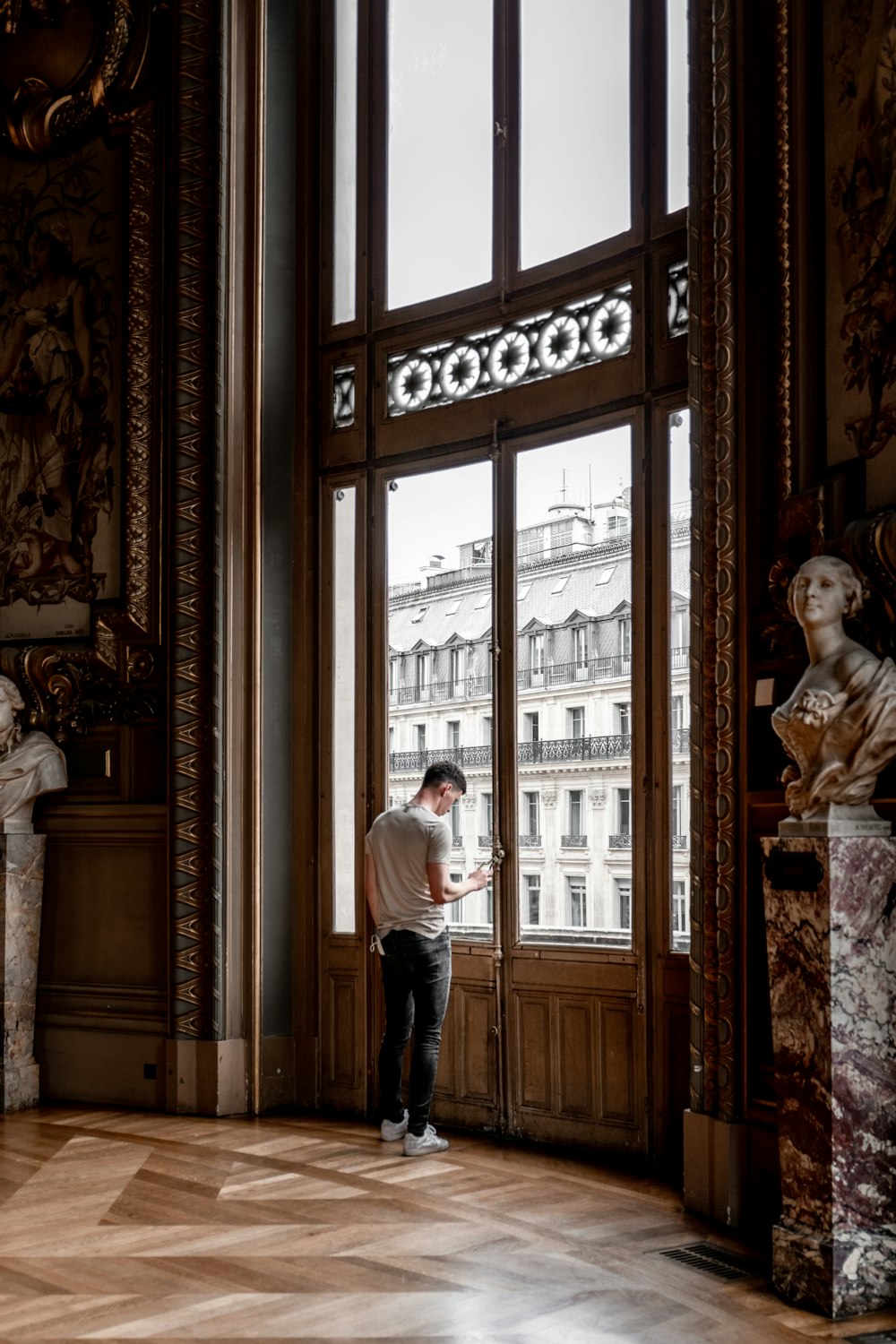 man in white shirt standing near window