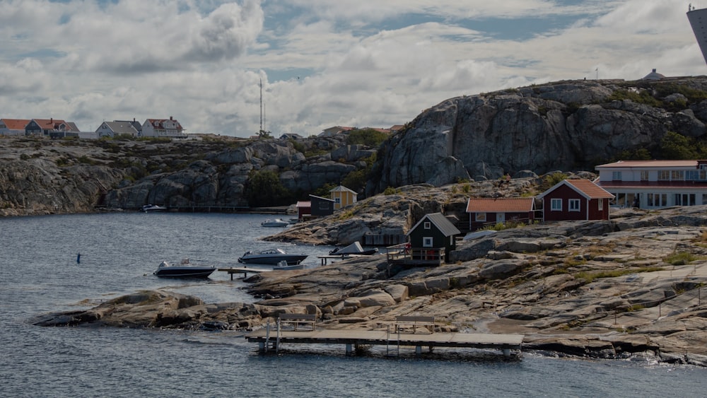 houses near body of water under cloudy sky during daytime