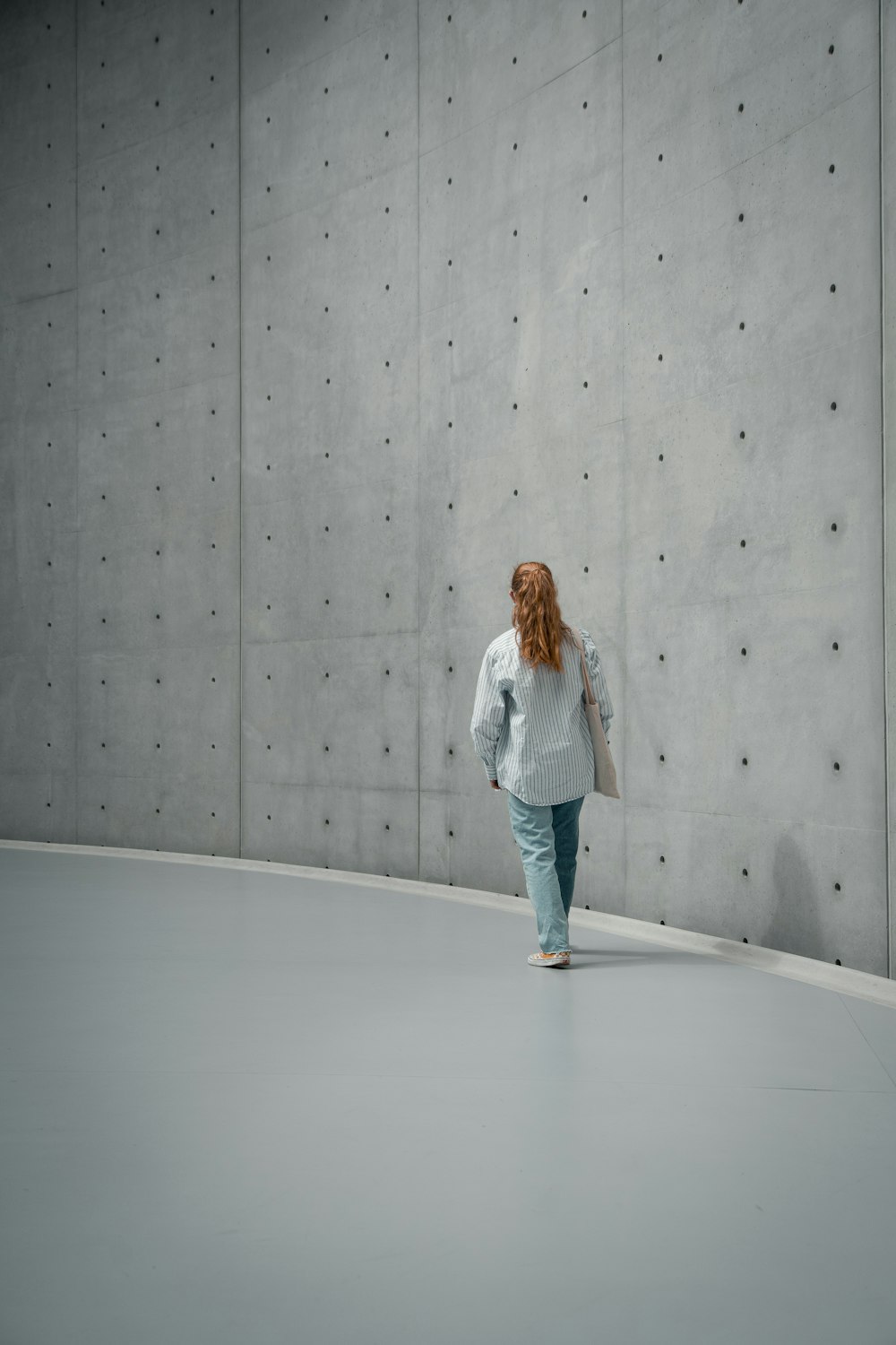 woman in white jacket and blue denim jeans standing on white floor