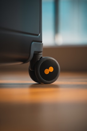 a close up of a black suitcase on a wooden floor