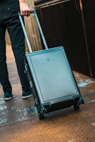 A traveler pulling a lightweight suitcase with smooth-rolling wheels through a busy airport terminal.