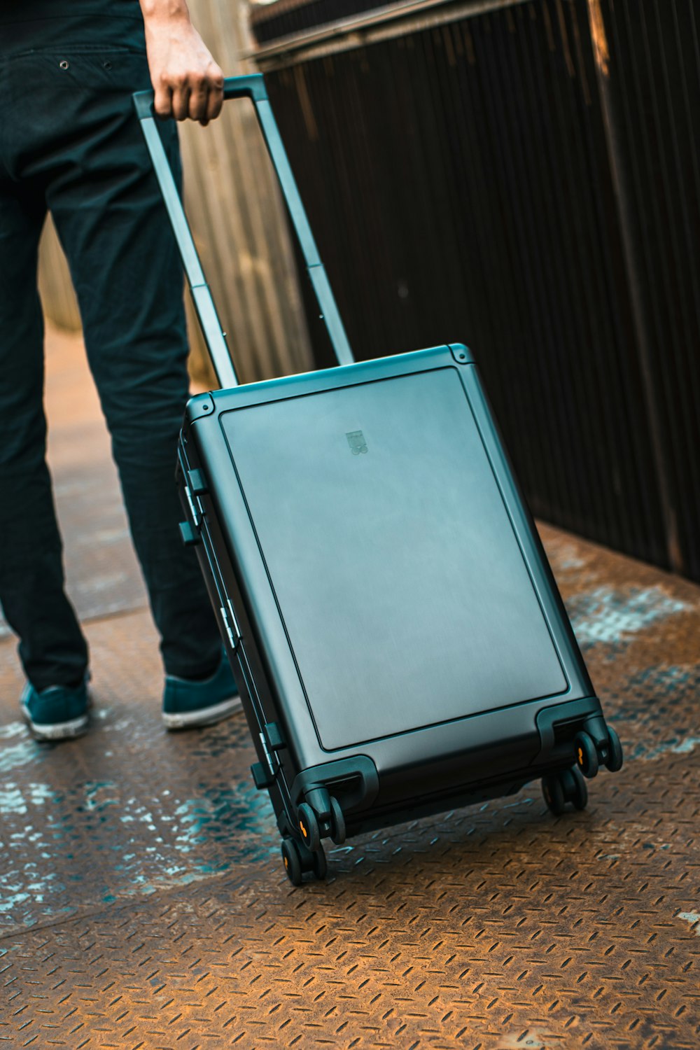 a person pulling a rolling suitcase on a sidewalk