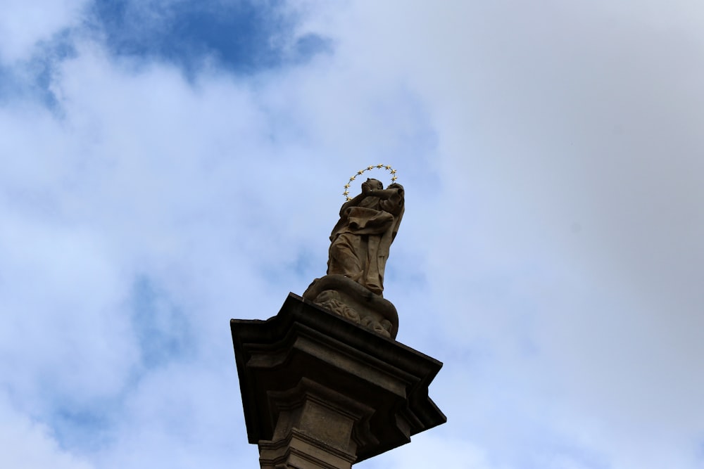 man in hat statue under white clouds