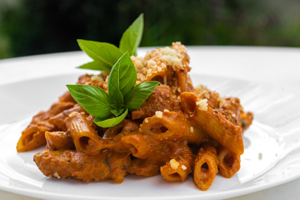 pasta with green leaf on white ceramic plate