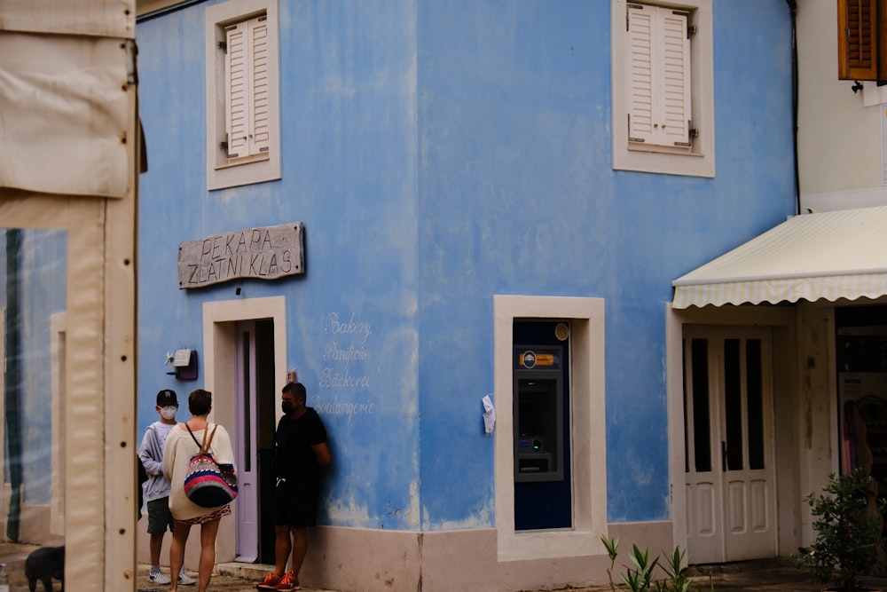 people standing in front of blue concrete building during daytime