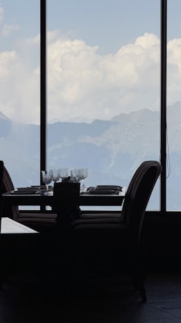 An elegant dining setup overlooking a scenic mountain landscape.