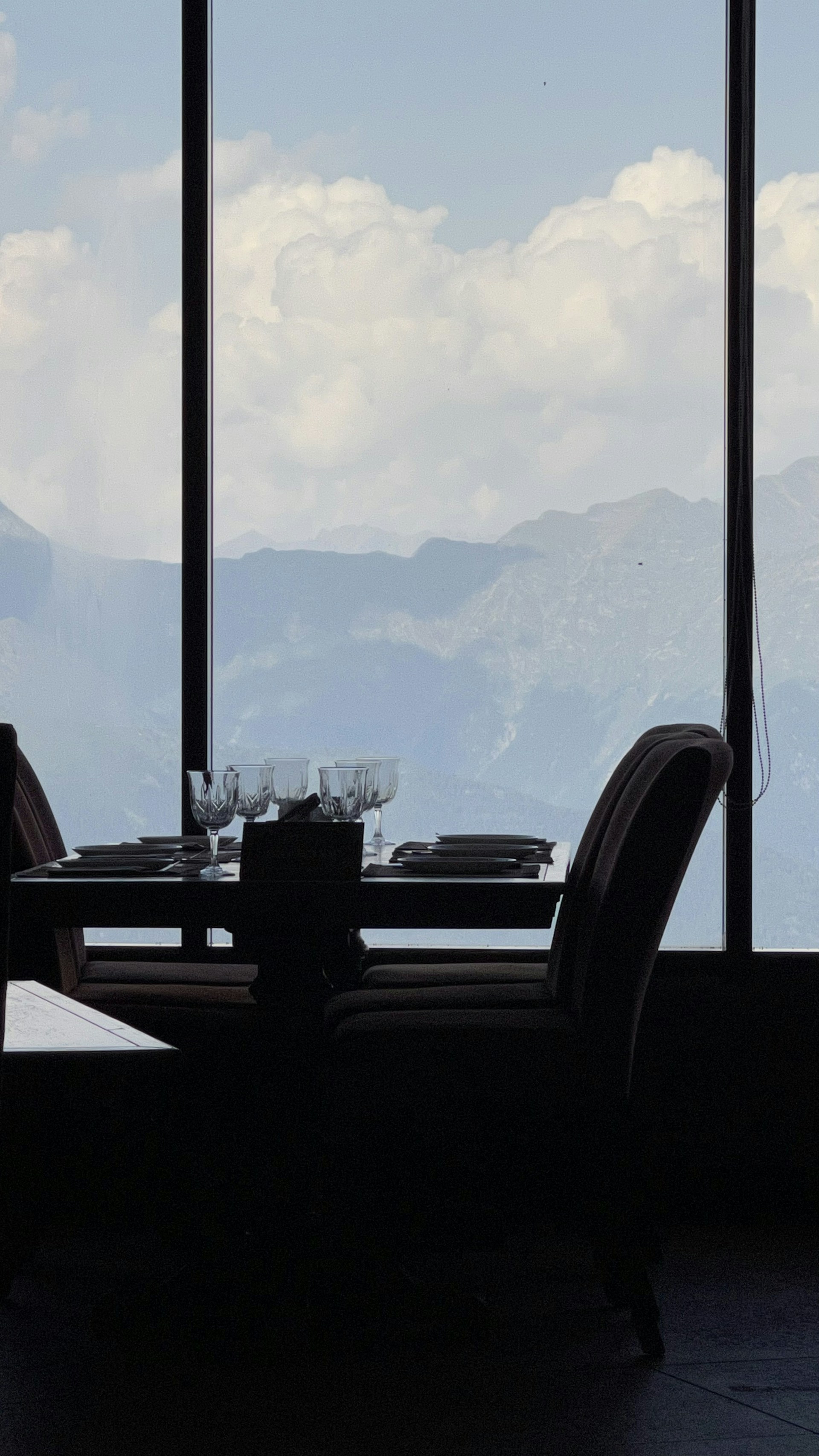 A beautifully arranged table set for a cozy dinner with mountain views in the background.