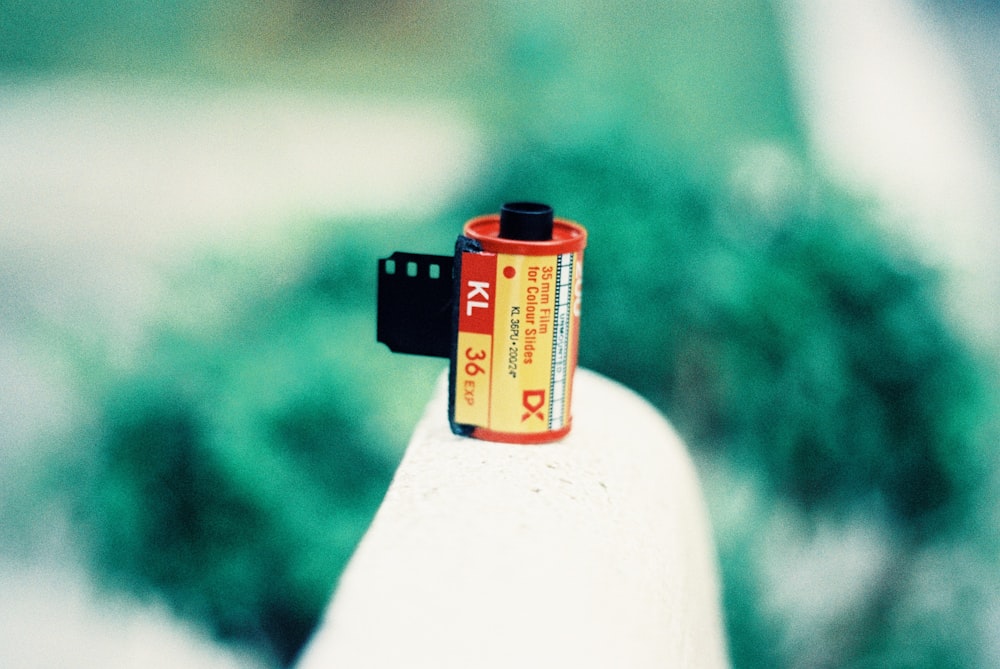 black and red plastic container on white plastic bottle