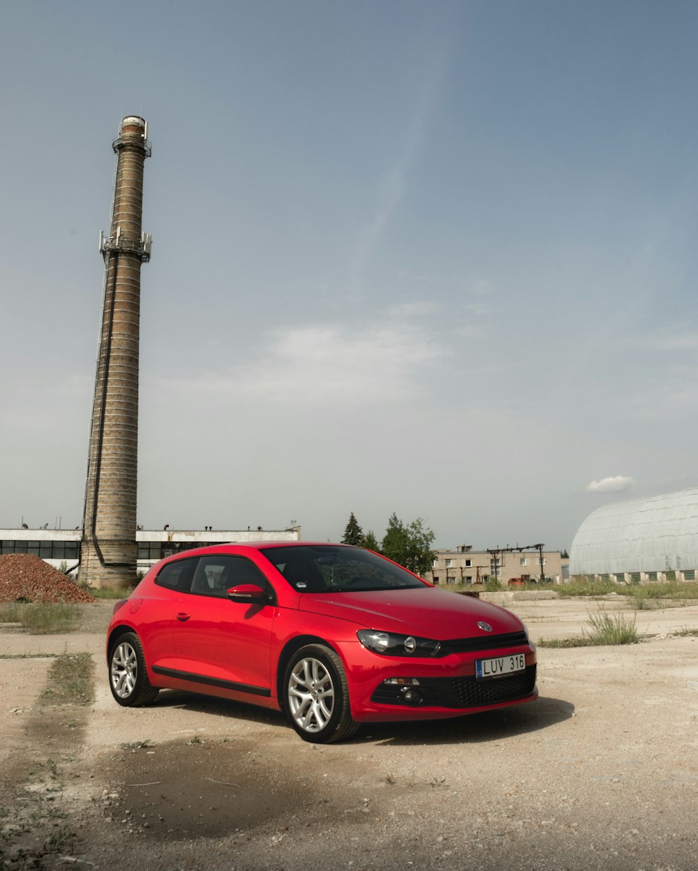 red honda car parked near brown concrete post during daytime