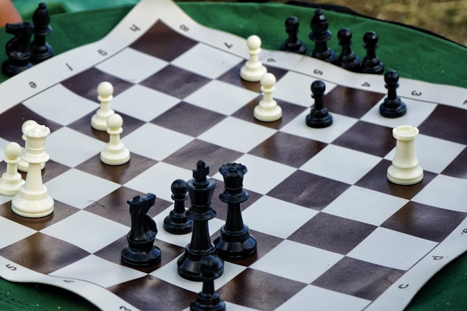 A black and white chess piece standing alone on a board in dramatic contrast