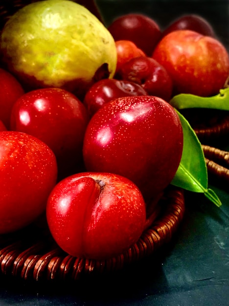 A vibrant basket overflowing with fresh colorful fruits and vegetables on a rustic wooden table