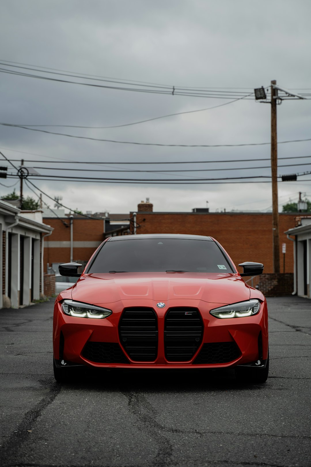 red bmw car parked on the side of the road