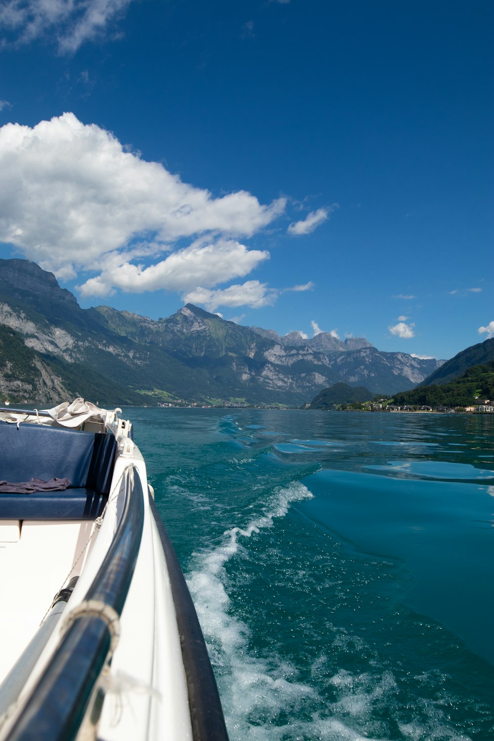 white boat on water near snow covered mountain during daytime