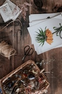Collection of small wooden objects with green plant accents on a rustic wooden table.