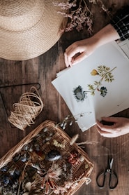 person holding white and green floral paper