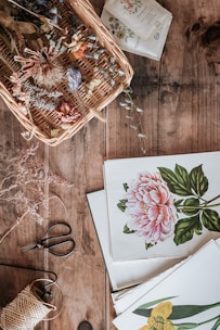 Nature-inspired printable designs laid out on a wooden table with greenery.
