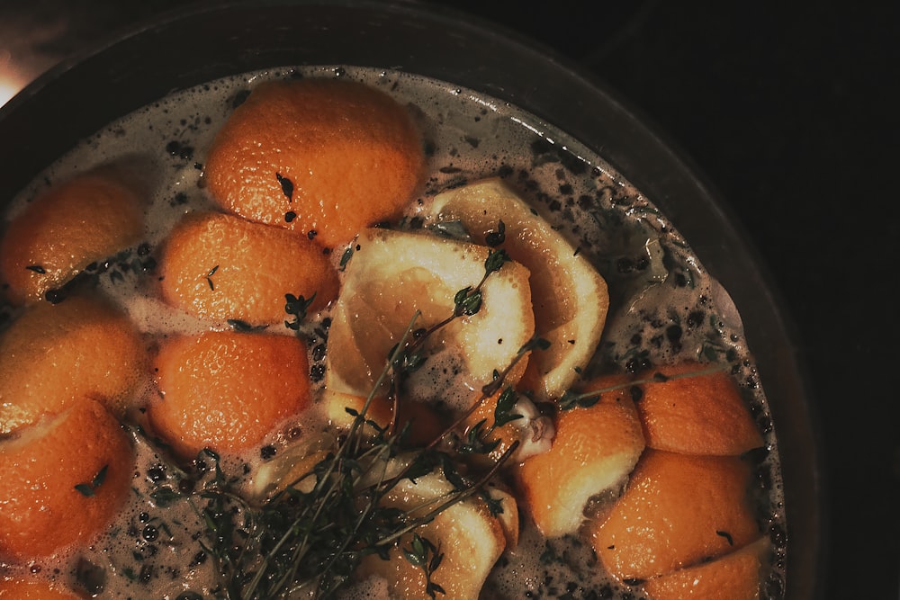 a pot filled with oranges and herbs