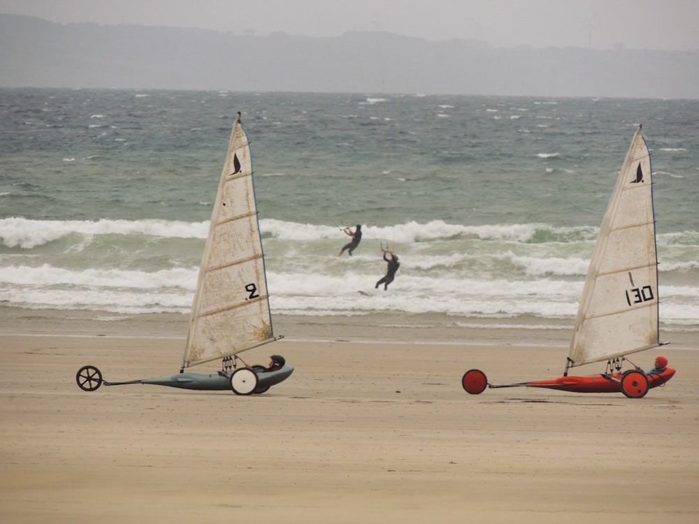 red and white sail boat on beach during daytime