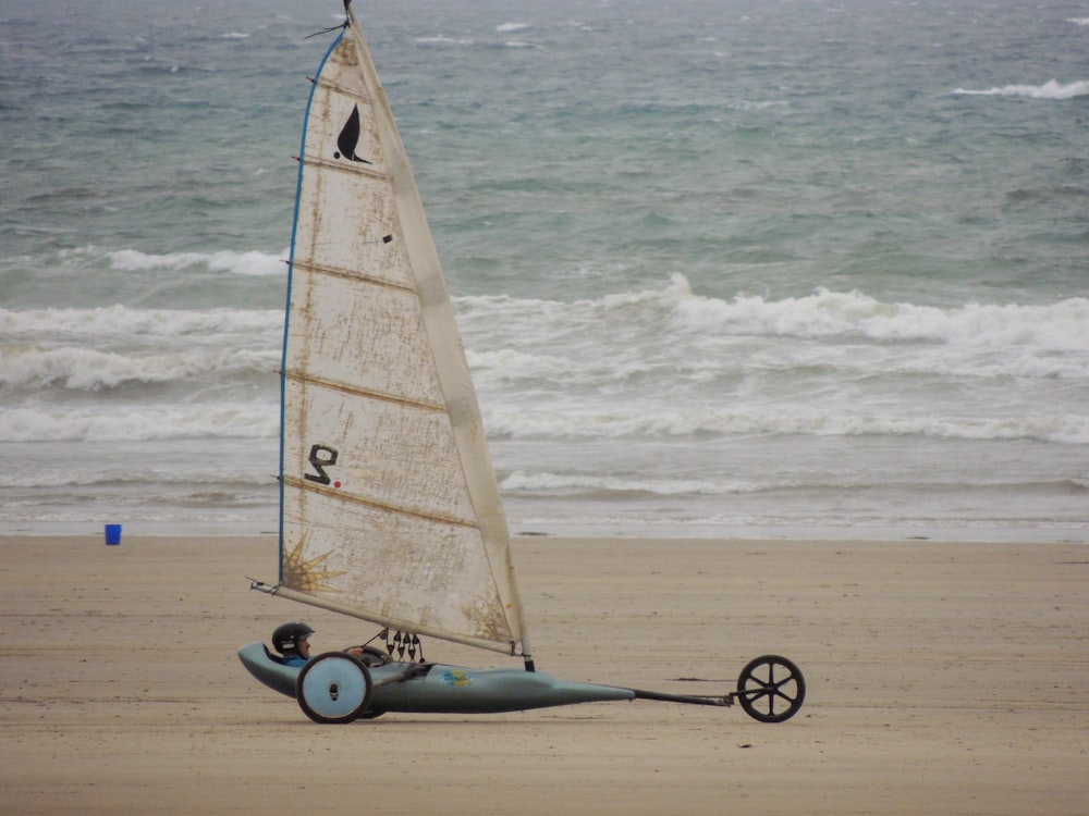 white and brown sail boat on beach during daytime