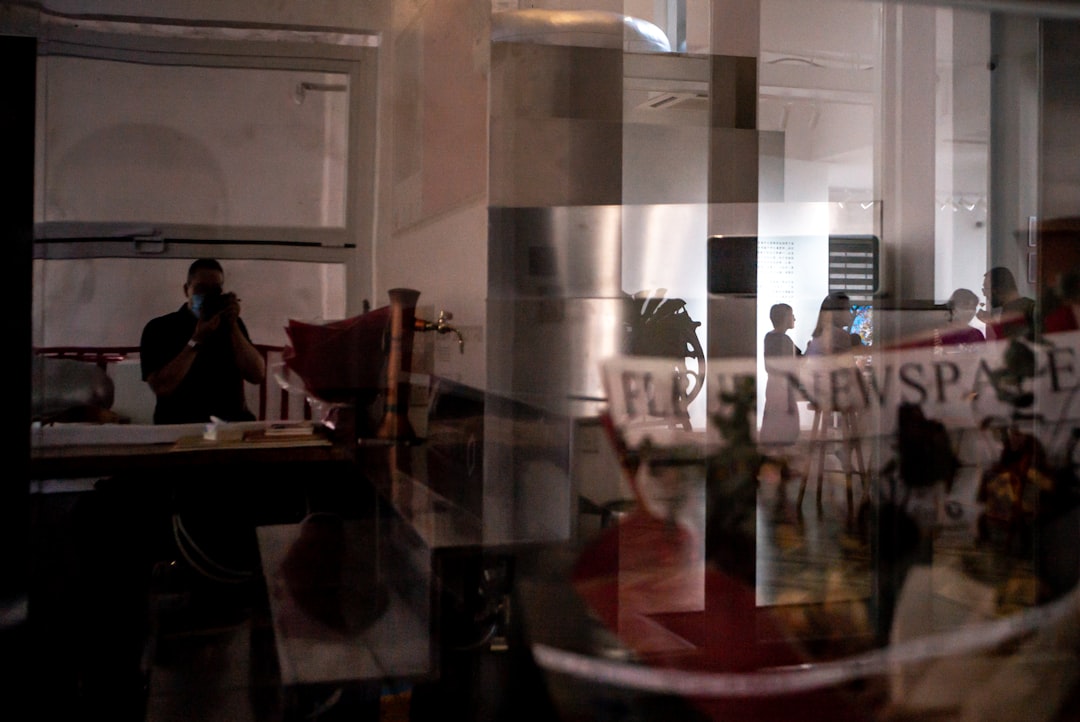 person in black shirt standing near glass door