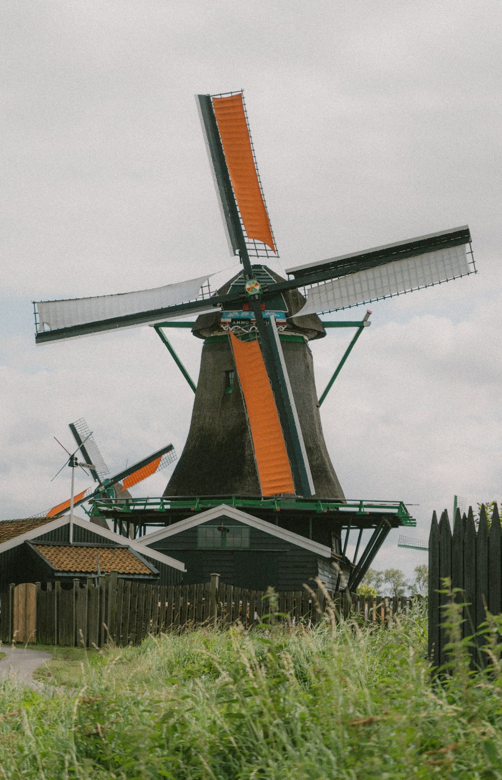 brown and gray windmill under white clouds during daytime