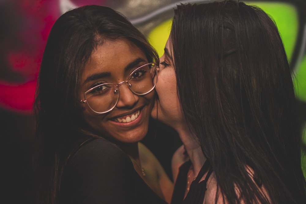 woman in black framed eyeglasses beside woman in black shirt