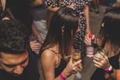 People gathering, having fun, and holding cocktail drinks at Hinges Bar in Houston, Texas.