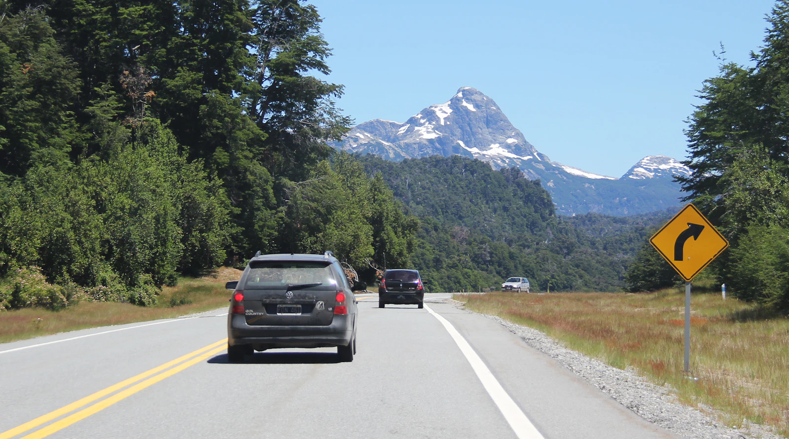 Cars following a signed bend on Ruta 40 between Villa La Angostura and San Martín
