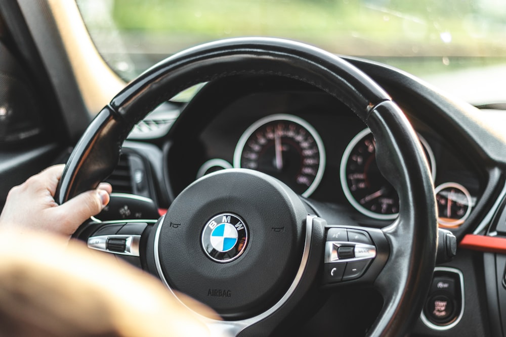 person driving bmw car during daytime