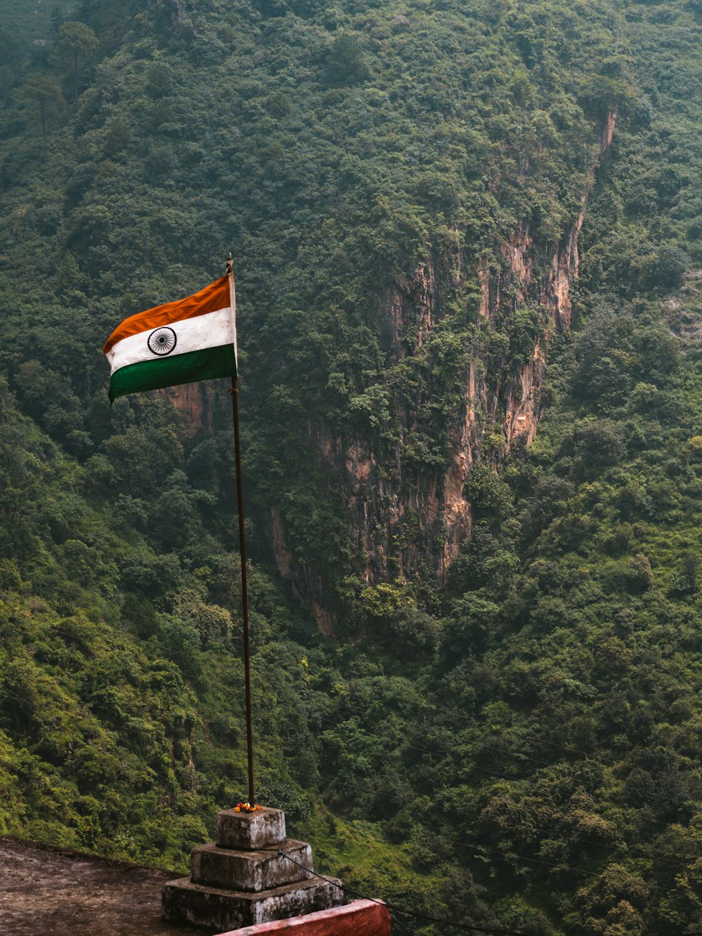 a flag on top of a mountain overlooking a valley