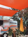man in white t-shirt sitting on orange plastic chair