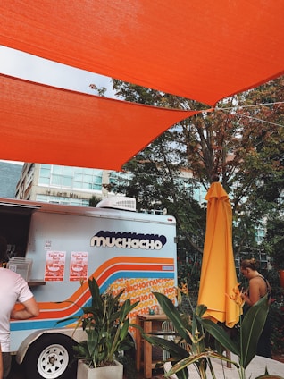 man in white t-shirt sitting on orange plastic chair