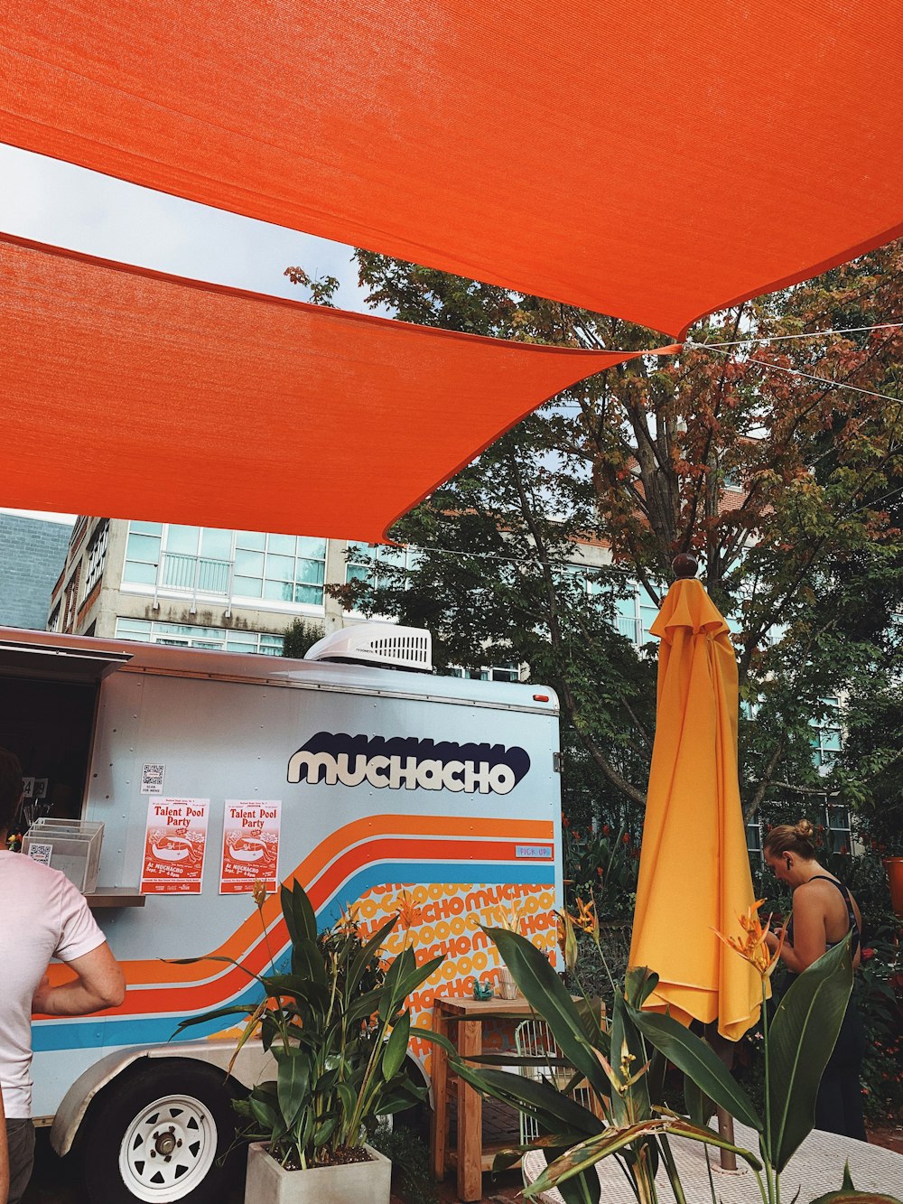 man in white t-shirt sitting on orange plastic chair