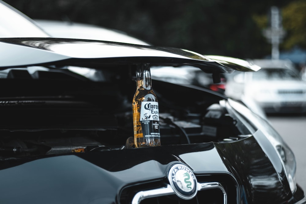 Botella de vidrio transparente en coche negro