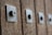 A close-up view of a series of metal bolts or studs affixed to a wooden surface, creating a textured pattern. Each bolt is embedded in a square metal plate, and the image captures a sense of rustic or industrial design.