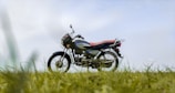 black and red naked motorcycle on green grass field