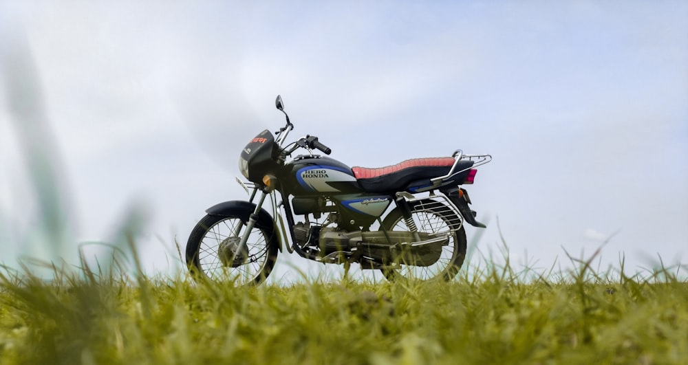 black and red naked motorcycle on green grass field