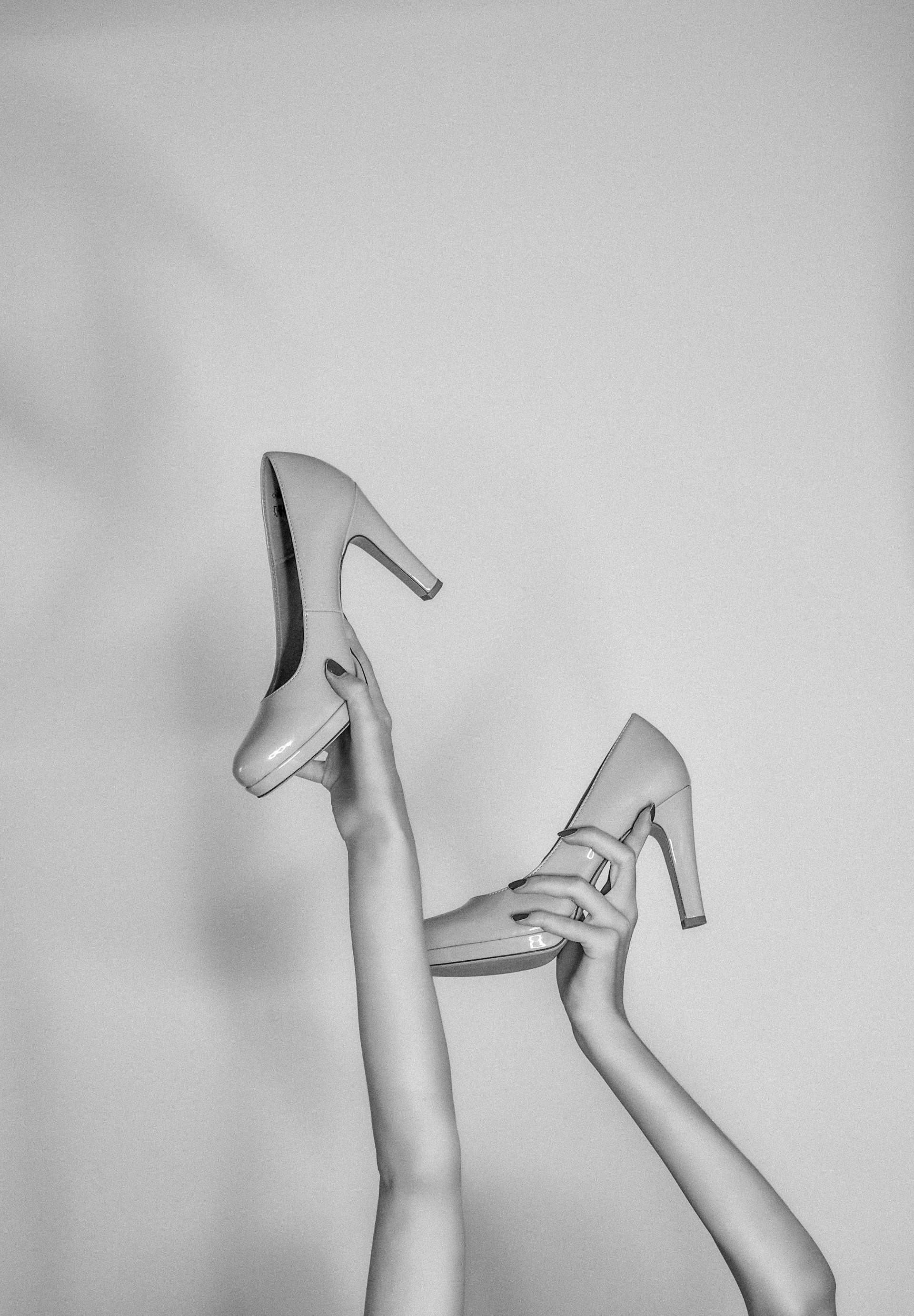 woman in black leather heeled shoes