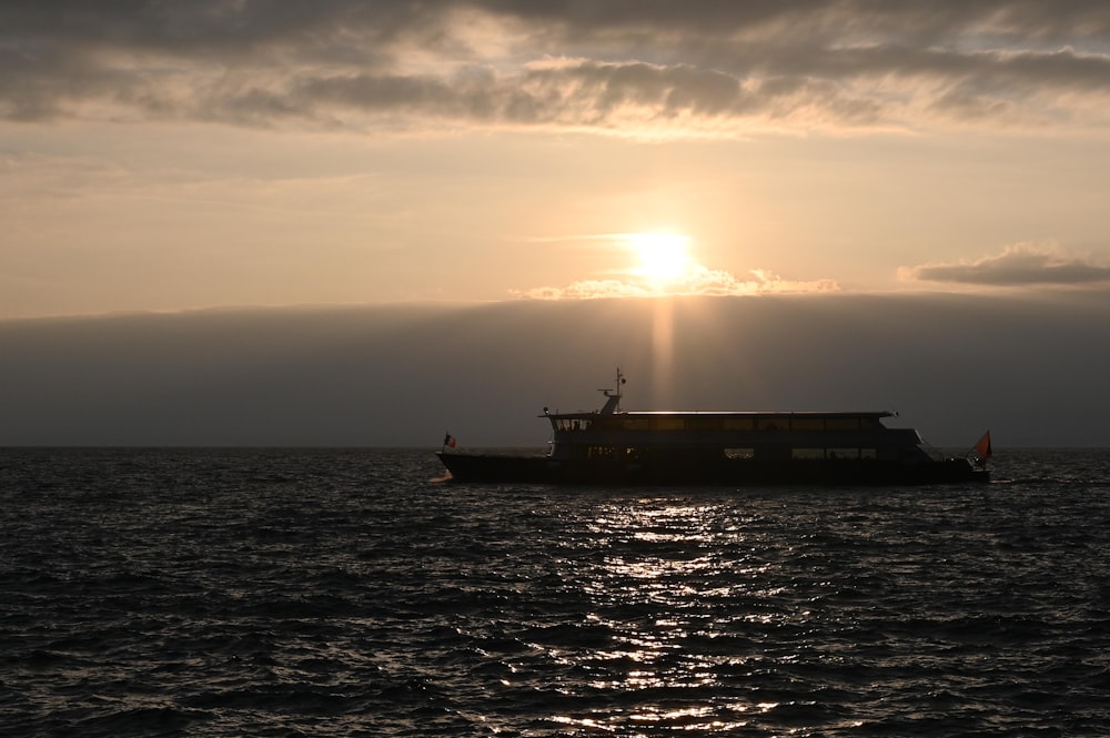 silhouette of ship on sea during sunset