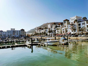 white boat on dock near buildings during daytime
