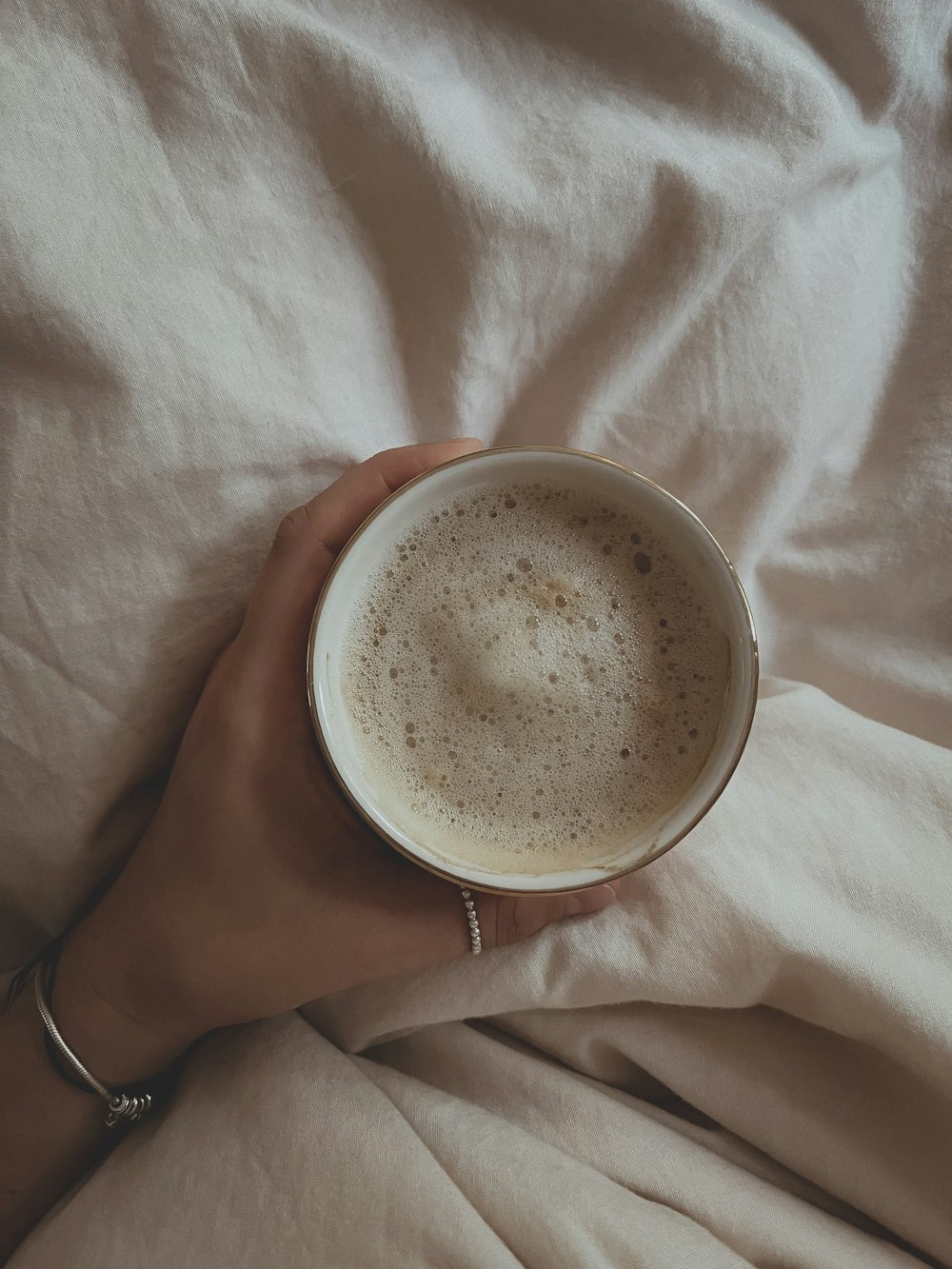 white ceramic mug on white textile