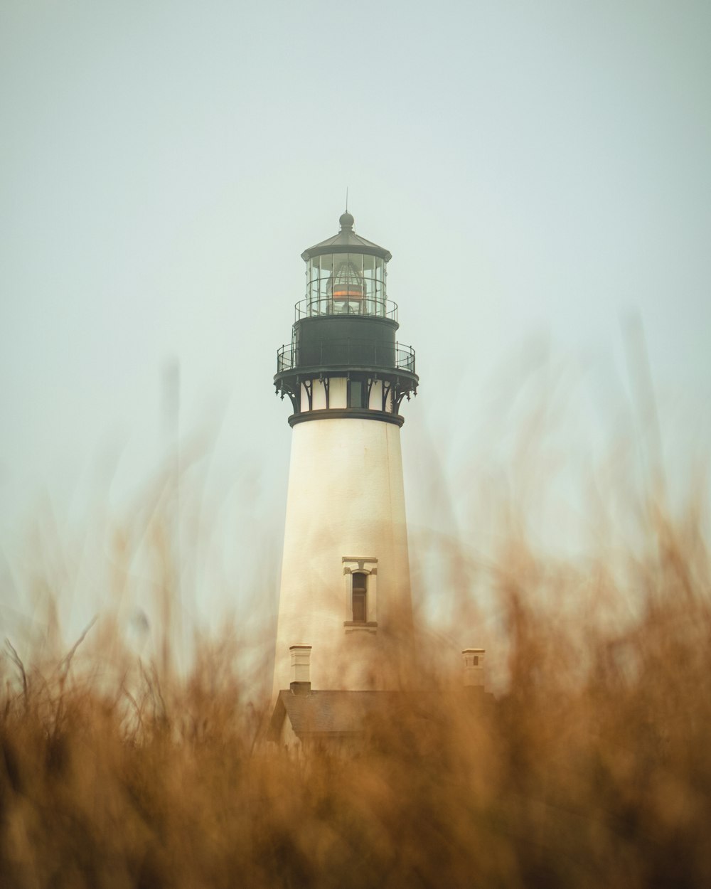 white and brown lighthouse under white clouds