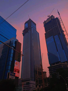 Photo showing workers installing a large billboard on a busy city street at sunset.