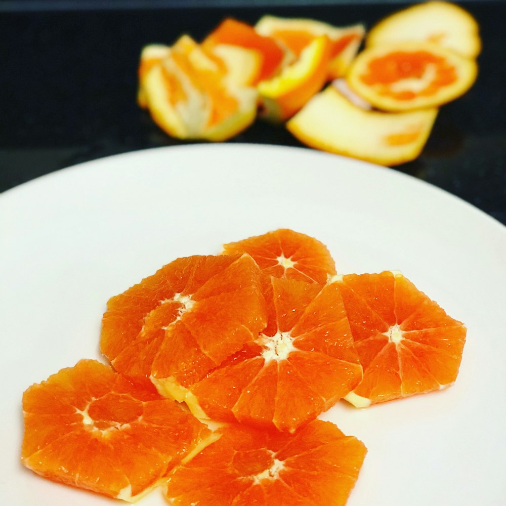 sliced orange fruit on white ceramic plate