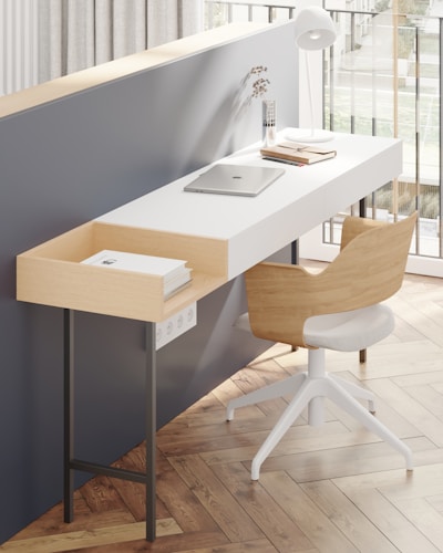 A sleek, minimalist workspace with a royal blue accent wall and clean white desk setup.