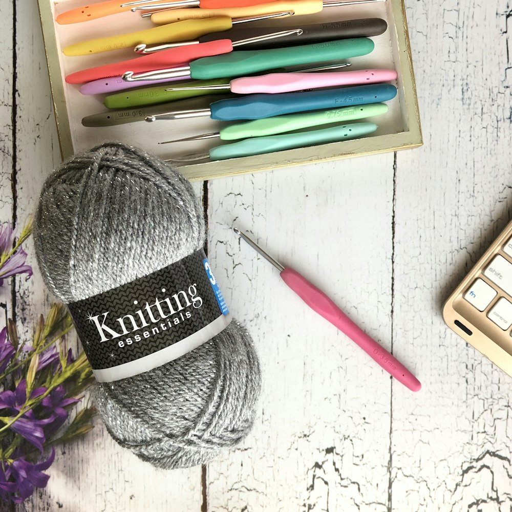 blue and white yarn ball beside pink pen